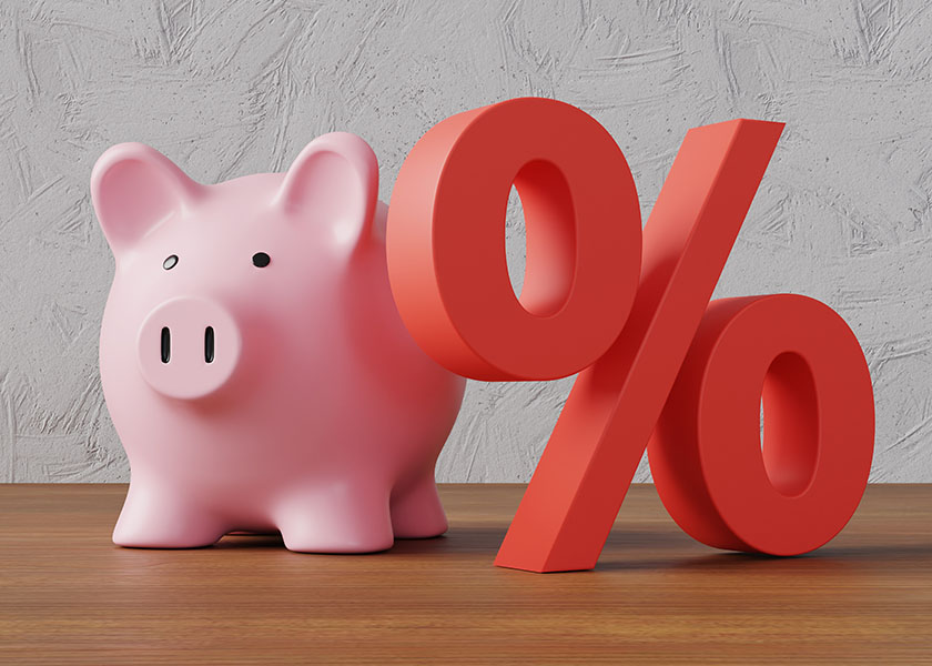 Pink piggy bank standing next to a red percentage sign. Compound interest.